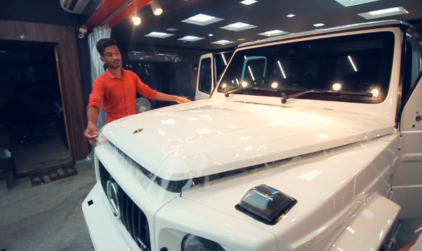 A worker applies PPF on a white SUV