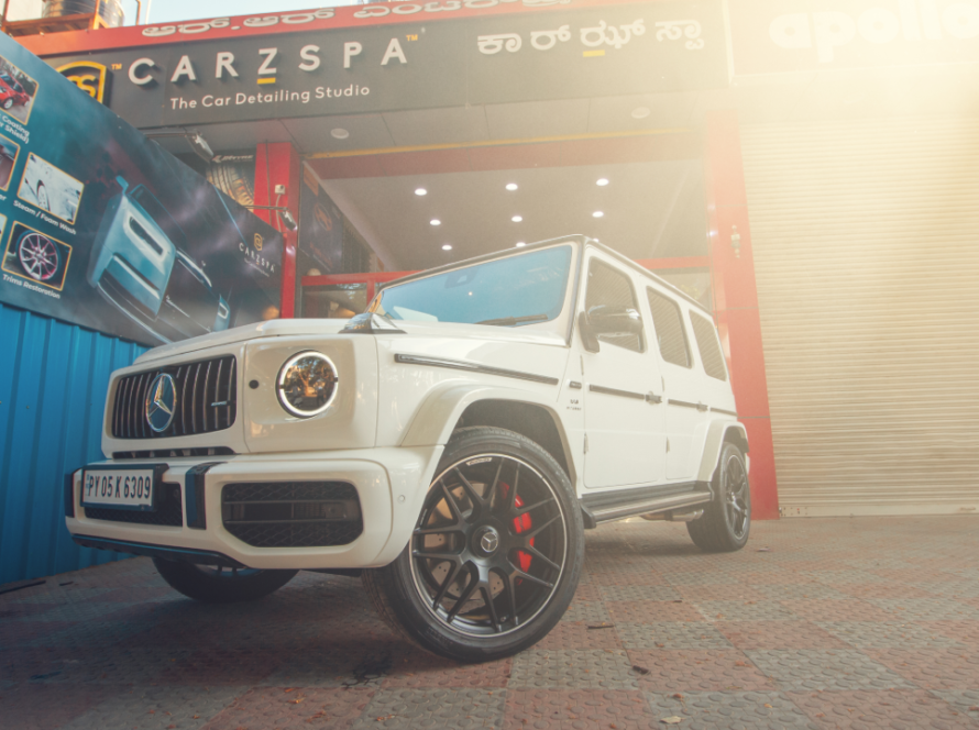 A white Mercedes G Wagon stands parked outside a CarzSpa Detailing Studio.