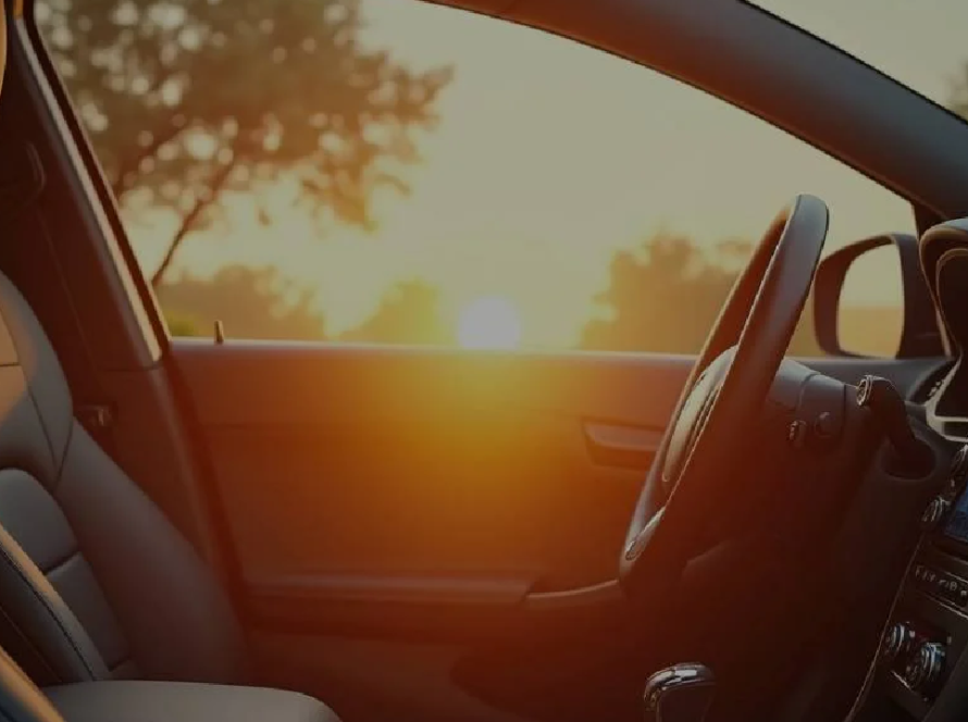 Image of car taken from inside such that sun is visible outside