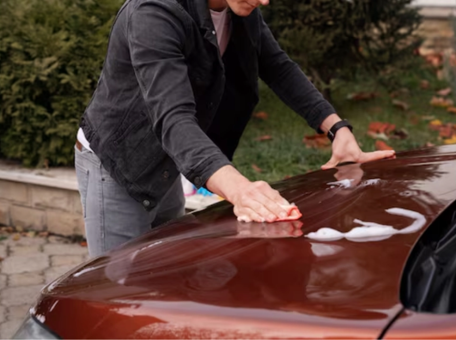 Close-up of a car owner applying a product on a PPF-coated car panel incorrectly