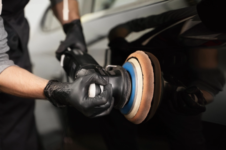 a close-up shot of a car’s external body being polished with a polishing tool