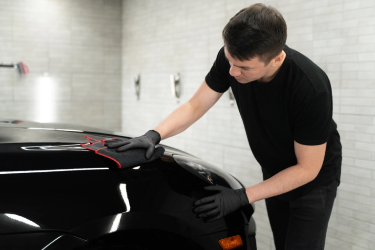 A man cleaning the car with microfibre cloth