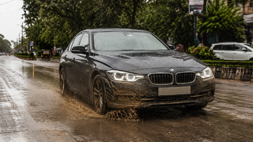 BMW driving through a muddy puddle on an Indian road