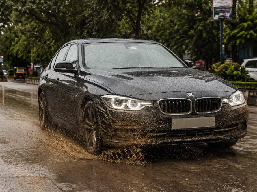 BMW driving through a muddy puddle on an Indian road